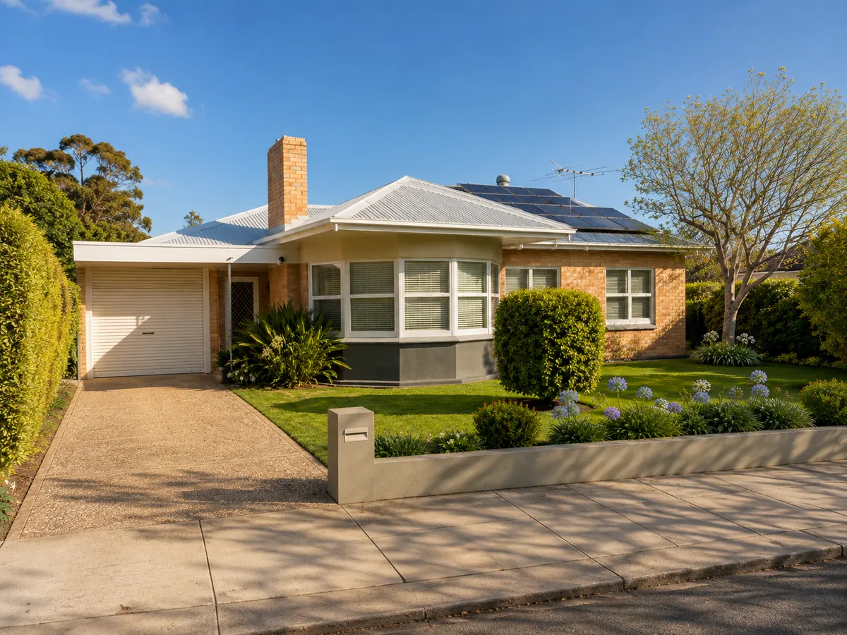 Brick South Australian family home with a tiled roof, established garden and driveway on a suburban street