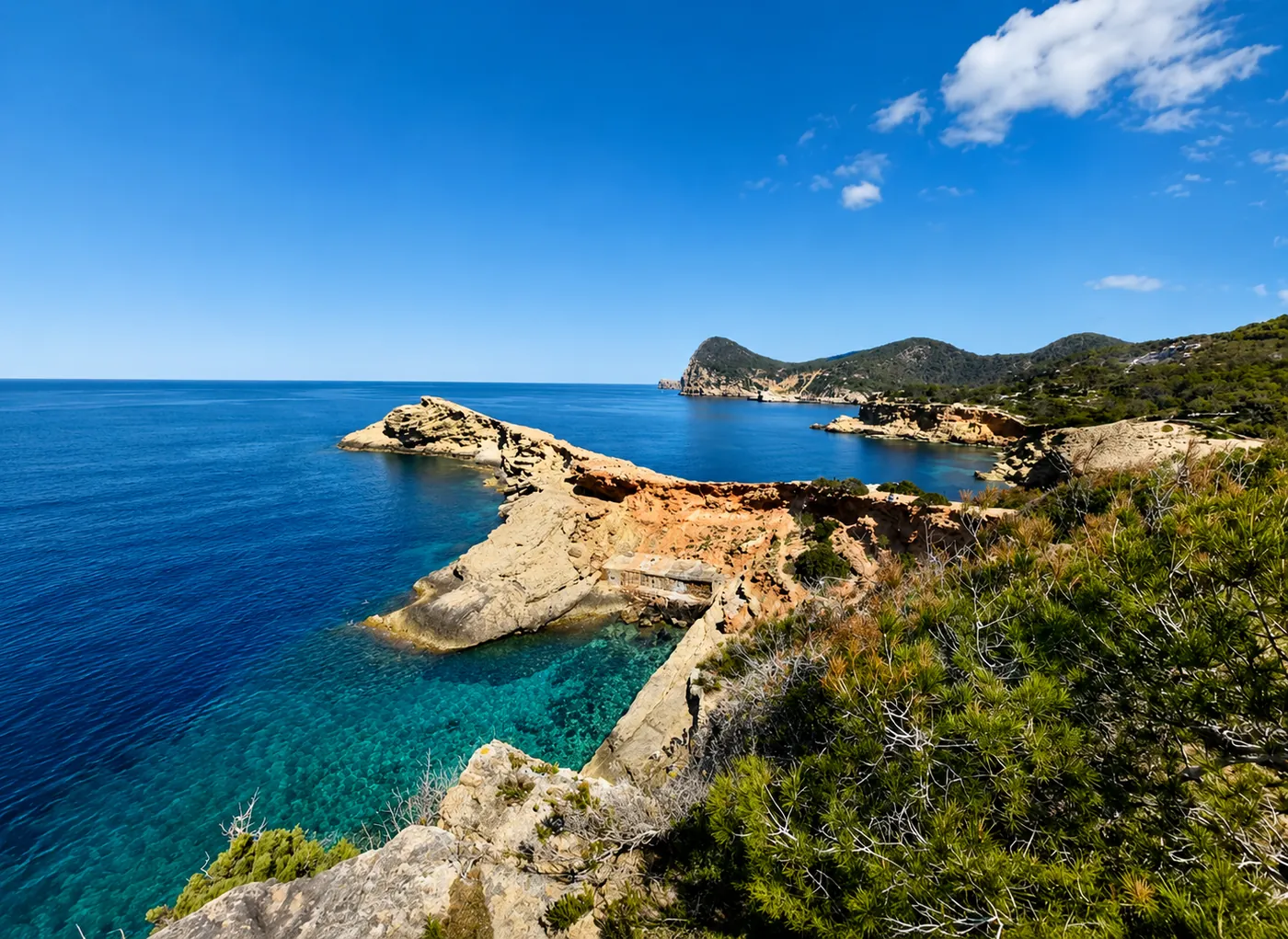 Mediterranean coastline near Ibiza with turquoise water, rocky headlands and green scrub